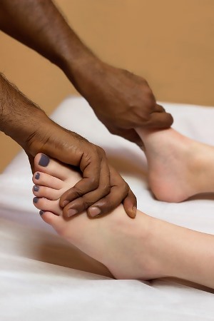 Michigan massage therapist performing foot massage on patient